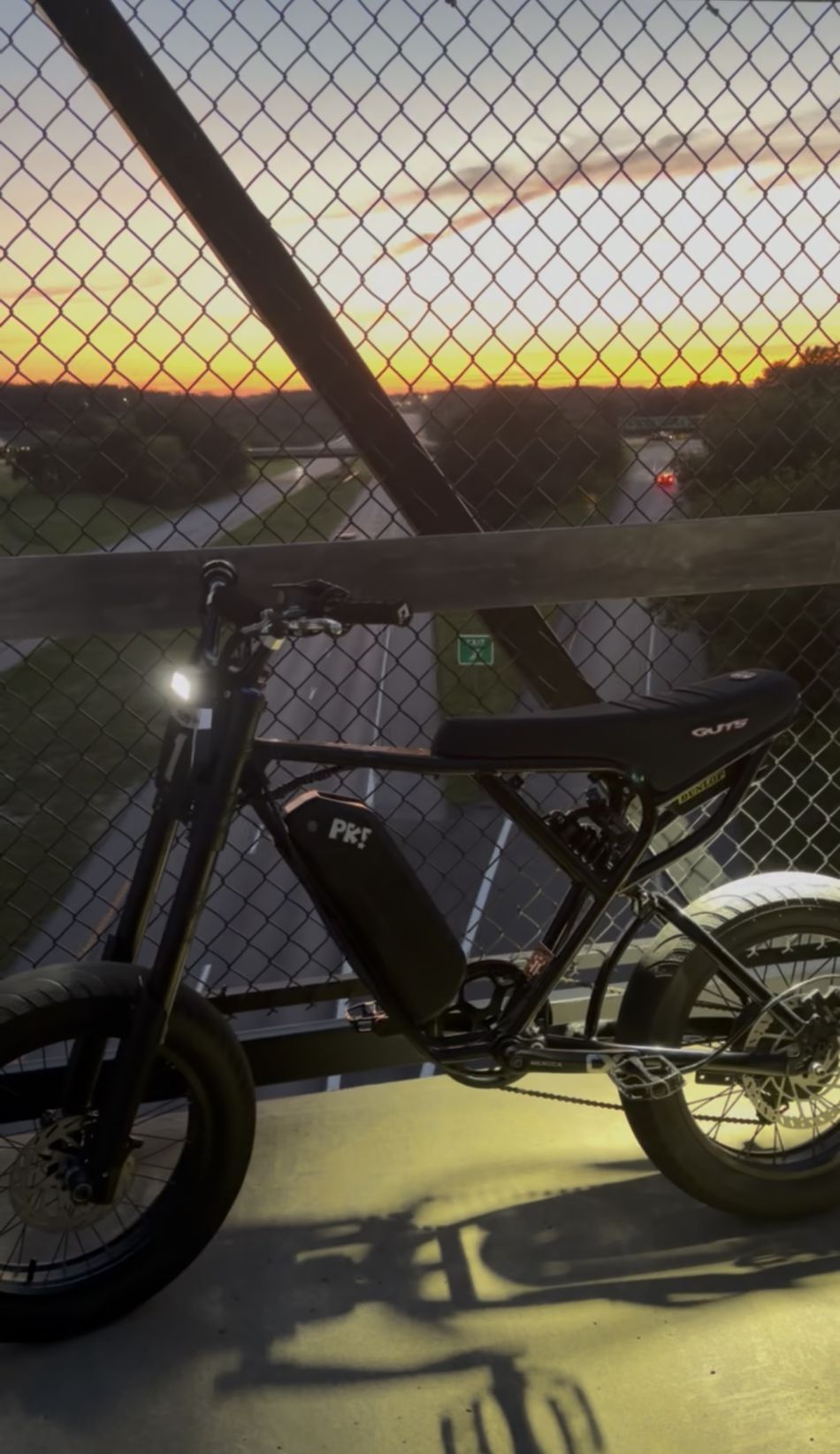 Black ebike running WFD lights at sunset on an overpass